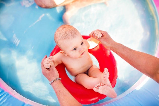 enfant dans un anneau de natation dans une piscine gonflable