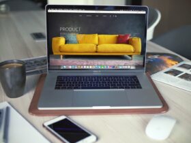 Turned on MacBook Pro beside gray mug